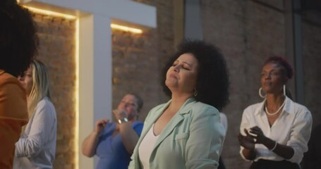Congregation clapping hands in prayer, close-up of diverse women with expressions of devotion and unity, celebrating faith and spirituality in a multicultural gathering