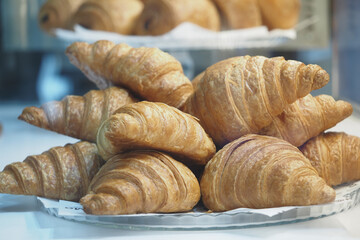 Freshly baked croissants displayed in a bakery case