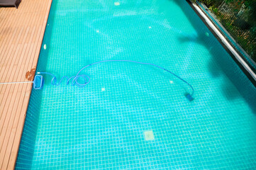 Pool maintenance with scoop net  and automatic robot cleaner.