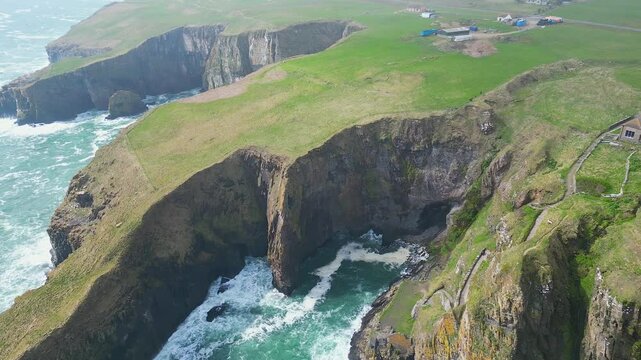 Aerial view of the Elephant Cliff and Whaligoe Steps during daytime in Whaligoe town, Scotland, UK