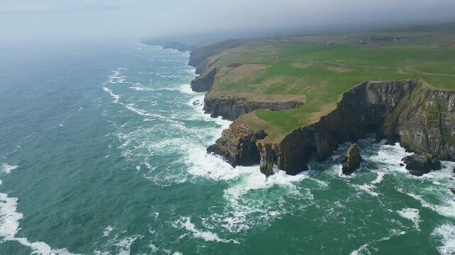 Aerial footage of the North Sea waves crashing on the Whaligoe Steps on a foggy day, Scotland, UK