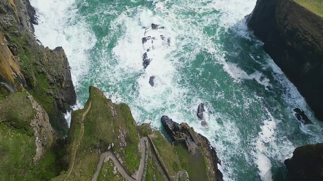 Bird's eye aerial view of the North Sea waves crashing on the Whaligoe Steps in Whaligoe, Scotland