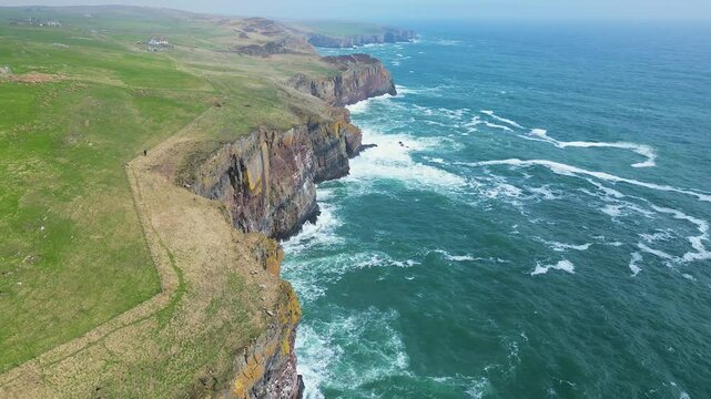 Aerial footage of the North Sea waves lapping on the cliffs on the coast of Whaligoe town, Scotland