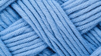A close-up of intertwined blue yarn, showcasing its texture and softness, ideal for knitting and crafting.