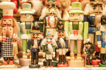 Group of colorful wooden nutcracker figurines in festive attire, part of traditional holiday decorations showcasing a variety of designs and vibrant colors