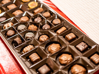 Box of assorted chocolates in a tray, featuring a variety of shapes and flavors