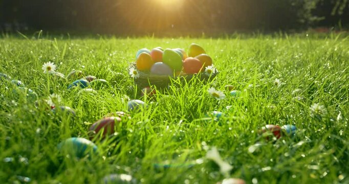 Easter eggs in basket in grass. Colorful decorated easter eggs in wicker basket.