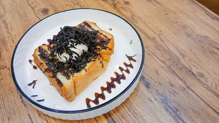 toast in a white plate with delicious chocolate sauce. Food concept with wooden table background.