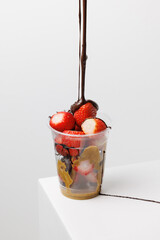 Pour chocolate over strawberry dessert