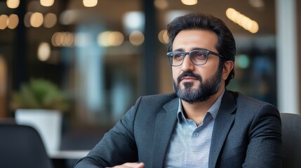 Naklejka premium Pakistani Man Supervising Team in Tech Startup Environment
