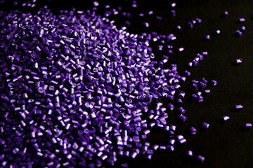 Purple pearl masterbatch granules, isolated on black background, color pigment carrier polymer in...