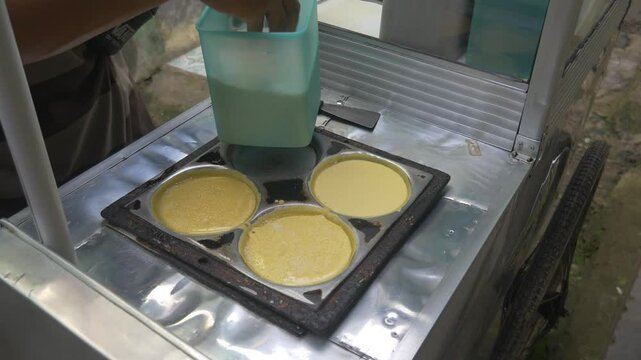 the process of making Martabak mini (Terang Bulan), a typical Indonesian street snack topped with chocolate and cheddar cheese.