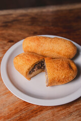 A minced view of a cassava bomb with meat inside on a wooden table.