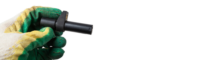 Electromagnetic crankshaft position sensor of a car engine in the hands of an auto mechanic. Spare parts catalog.