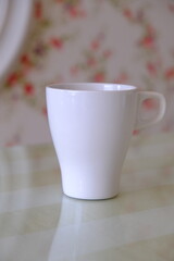 top view shot of a pink and green theme with pink flowers wallpaper,  and partially visible white cup set with text space for your message, love, soft, feminine and romantic valentines concept