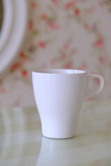 top view shot of a pink and green theme with pink flowers wallpaper,  and partially visible white cup set with text space for your message, love, soft, feminine and romantic valentines concept