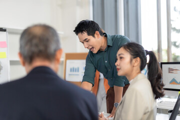 Asian manager explaining project to colleagues during office meeting
