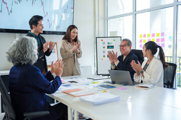 Diverse Business Team Clapping Hands During a Meeting in Modern Office