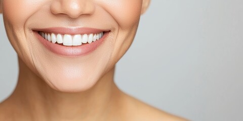 Obraz premium Women's History Month Concepts. Smiling woman showcasing healthy, bright teeth against a neutral background.