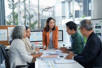 Asian businesspeople discussing financial charts and graphs during a meeting
