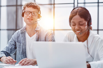 Obraz premium Young friendly operator woman agent with headsets working in a call center