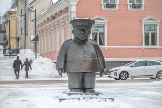 Oulu, Finland: A bronze statue of a fat, stern market policeman. Harsh Finnish snowy winter.