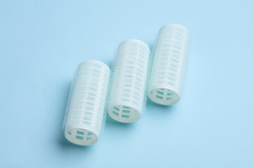 Plastic hair curlers on blue background