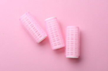 Plastic hair curlers on pink background