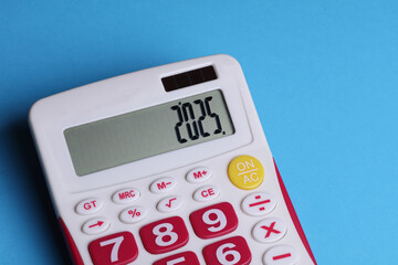 Calculator with number 2025 on blue background. Economic analysis, budget of the year
