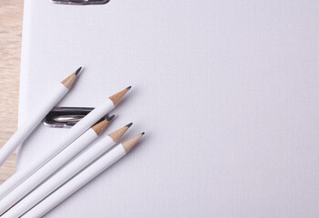 White wooden pencils with folder on table. Mockup for design