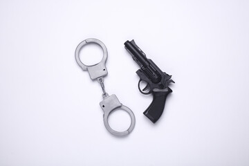Toy gun with handcuffs on white background