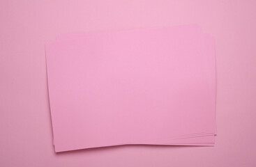 Pink sheets of paper of A4 size on a pink background