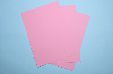 Pink sheets of paper of A4 size on blue background