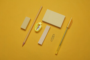 Set of school stationery on yellow background. Monochrome photography. Flat lay. Creative layout