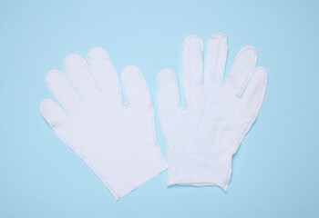White fabric gloves on a blue background