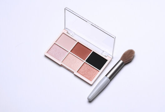 Makeup eyeshadow palette and brush on white background