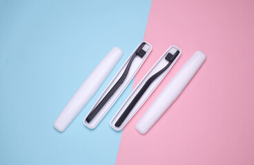 Plastic cases with toothbrushes on blue pink background