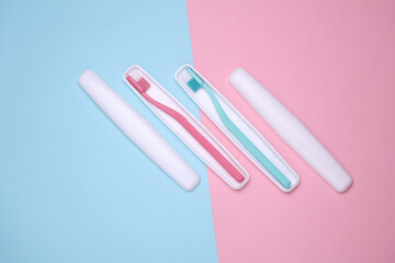 Plastic cases with toothbrushes on blue pink background