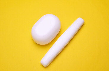 Toothbrush and soap cases on yellow background