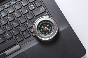 Laptop and compass on white background. Business concept