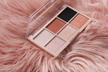 Makeup eyeshadow palette on pink fuzzy background