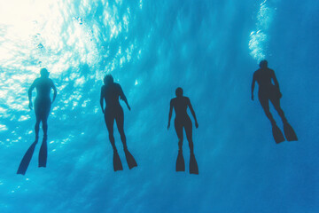 Four people are swimming in the ocean, with their feet in the water