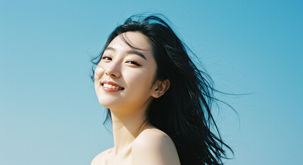 爽やかな風と青空と若いアジア人女性