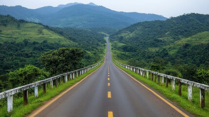 Obraz premium Winding scenic mountain road leading through a lush green countryside landscape with a bridge crossing over a valley A picturesque serene vista of rolling hills forests and meadows