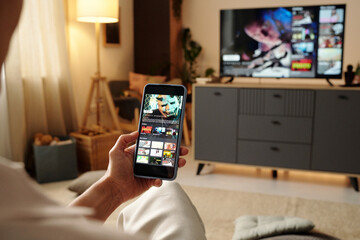 Watching TV Shows on Smartphone in Cozy Living Room