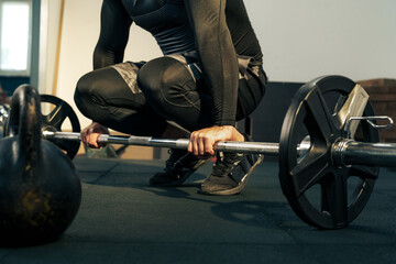 Strong individual preparing for a deadlift in a gym during early morning workout session