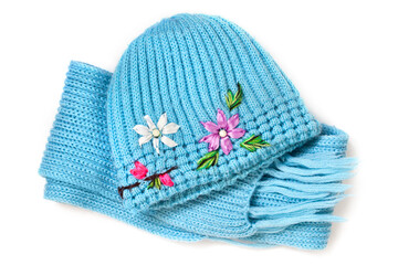 Woolen blue hat and scarf on a white background. A set of winter knitted clothes.