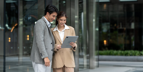 Group of Asian business people walking outside in front of office buildings.Southeast asian Business people group coworker working at outdoor city urban,communication or networking together concept.