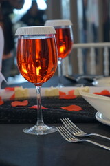 cool red fizzy drinks in the glass on dinner table. suitable for drinking during the day. Selective focus close up.