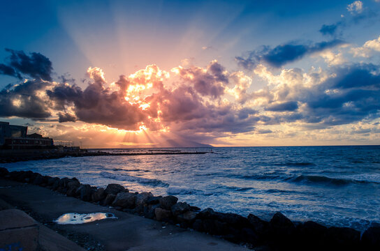 sunset behind clouds,  over the sea